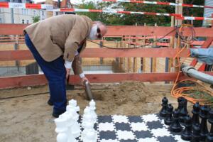 Der Vorsitzende der Schachgemeinschaft Leipzig Uwe Attig versenkt die Urne