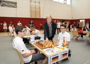 Gabi Ohler, Staatssekretärin für Bildung, Jugend und Sport des Freistaats Thüringen, eröffnet am Brett von Emil Schmidek und Roven Vogel das Turnier