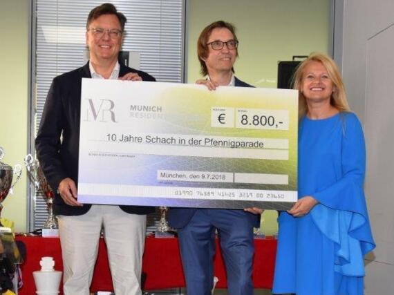 Roman Krulich überreicht den Spendenscheck für Sponsor Munich Residential