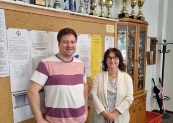 DSB-Vizepräsidentin Olga Birkholz zusammen mit dem Spitzenbrett der DSOL-Siegermannschaft, IM Christian Braun vor der beeindruckenden Wand mit Siegertrophäen der SG Porz.